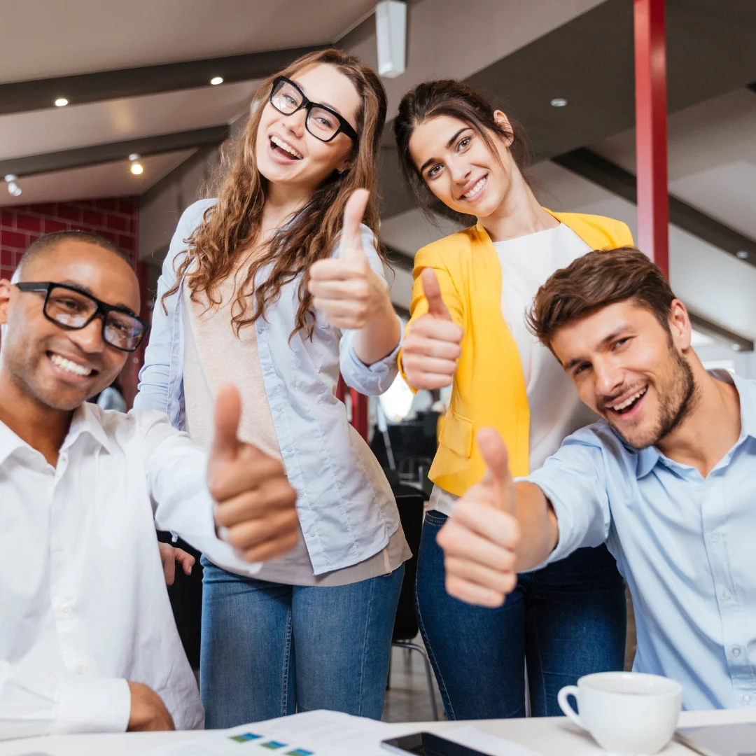 Grupo de pessoas sorrindo e fazendo sinal de positivo, representando a aprovação dos clientes da Seguraliza, corretora de seguros.